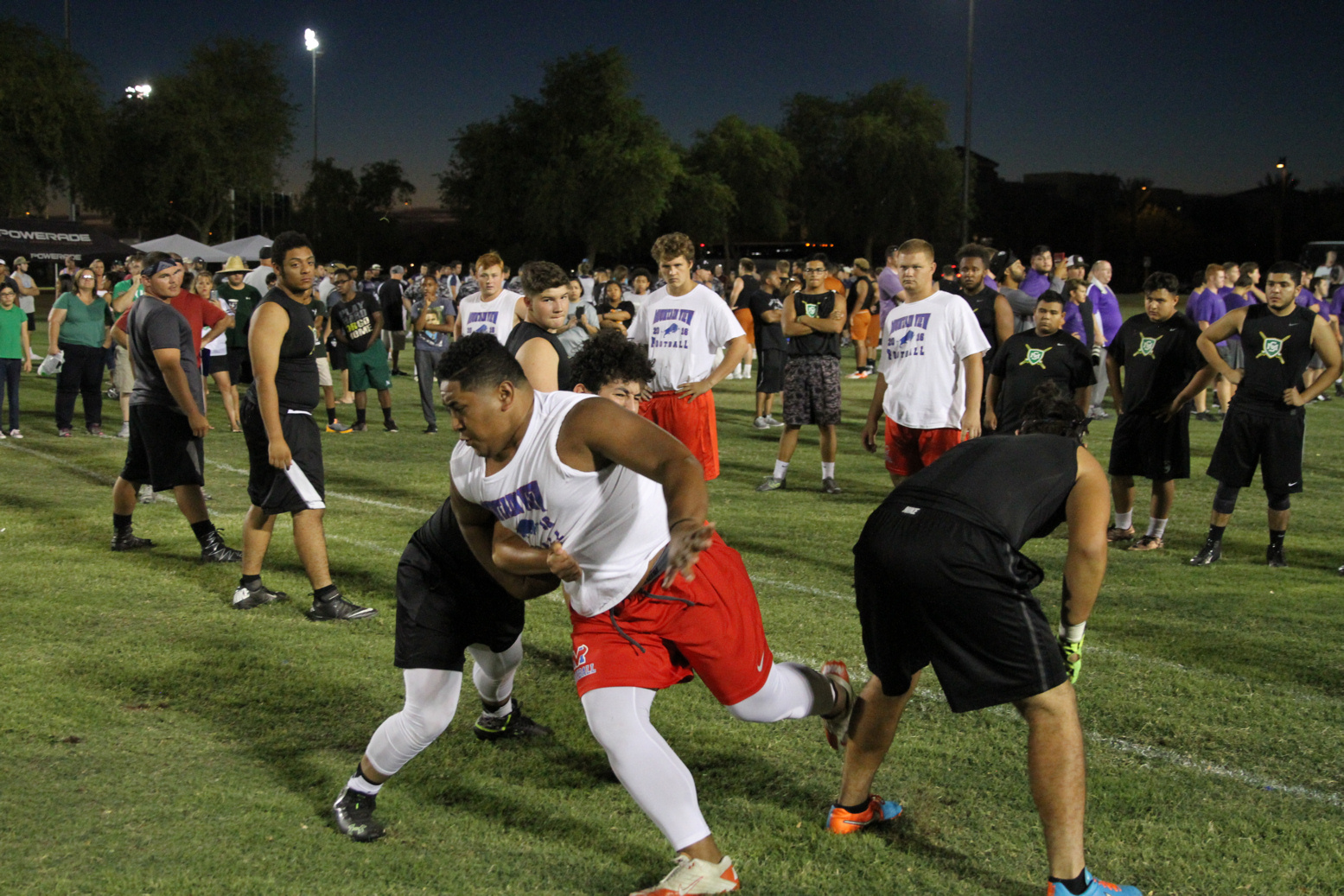 Football players tackle each other outside